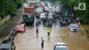 Polisi dan petugas Dinas Perhubungan mengatur lalu lintas saat banjir menggenangi Jalan Perintis Kemerdekaan, Pedongkelan, Jakarta, Sabtu (2/8/2020). Banjir mengakibatkan lalu lintas dari Pulo Gadung menuju Senen dan arah sebaliknya macet. (merdeka.com/Imam Buhori)