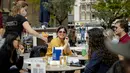 Pelanggan menikmati minuman di teras di Neude plaza di Utrecht, Belanda Barat, Rabu (28/4/2021). Pemerintah Belanda mulai melonggarkan pembatasan ketat terkait Covid-19, mengakhiri jam malam yang kontroversial dan mengizinkan kafe untuk buka di luar ruangan. (ROBIN VAN LONKHUIJSEN/ANP/AFP)