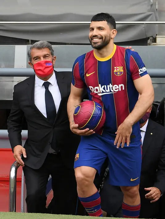 Penyerang Sergio Aguero tersenyum saat tiba untuk sesi foto selama presentasi resminya sebagai pemain baru Barcelona di stadion Camp Nou, Spanyol (31/65/2021).  Barcelona resmi mengontrak Sergio Aguero dari Manchester City dengan kesepakatan hingga 2023. (AFP Photo/Lluis Gene)