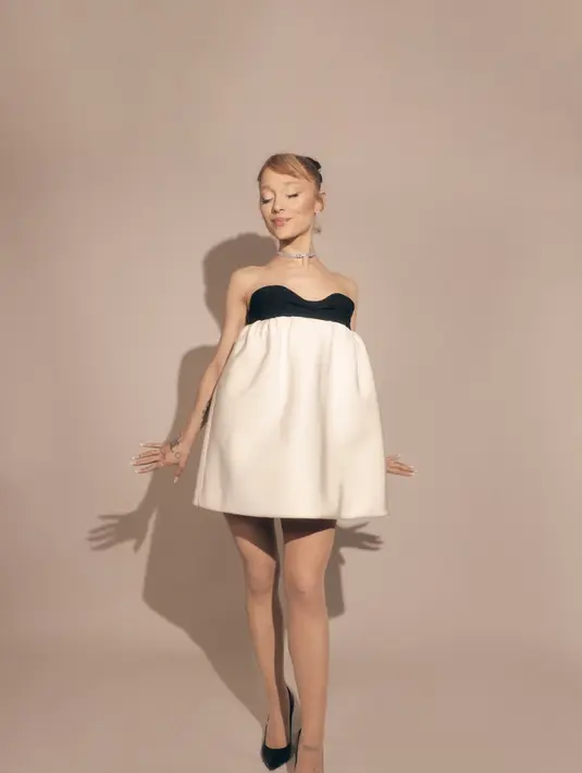 Dress bustier satin dengan nuansa monokrom juga tampak selaras dengan tas yang dikenakannya.