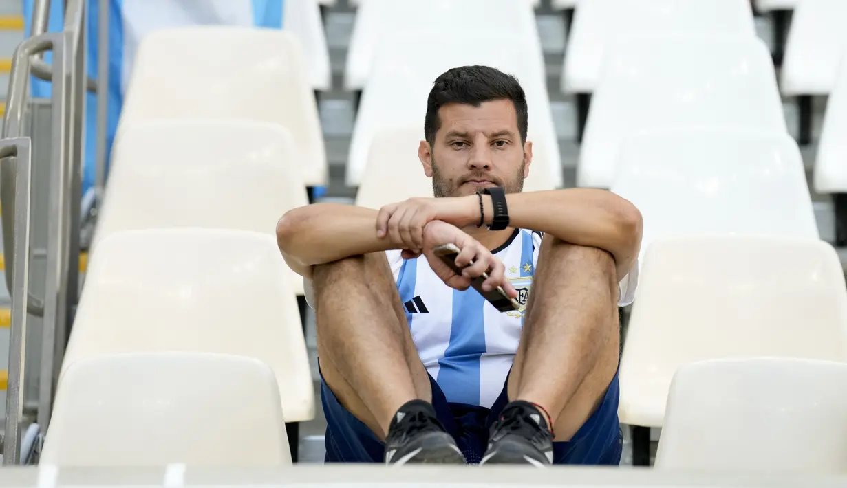 Seorang fans Argentina duduk di tribun setelah timnya kalah dari Arab Saudi pada laga pertama pertama Grup C Piala Dunia 2022 Qatar di Stadion Lusail, Selasa (22/11/2022). Lionel Messi dkk. menjadi favorit juara Piala Dunia 2022, tetapi justru harus tumbang di laga pertamanya. (AP Photo/Jorge Saenz)