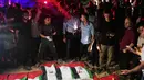 Warga Palestina berkumpul mengelilingi jenazah warga Palestina yang tewas dalam serangan Israel selama perang dengan Hamas setelah ditemukan dari bawah reruntuhan bangunan. Jenazah yang dibungkus bendera Palestina tersebut diiringi warga dalam prosesi pemakaman di Kota Gaza, Rabu (30/9/2026). Prosesi berlangsung dalam suasana duka, dengan keluarga dan warga setempat berkumpul untuk memberikan penghormatan terakhir kepada para korban. (AP Photo/Jehad Alshrafi)