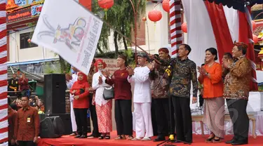 Sambil mengayunkan bendera, Presiden Jokowi memberi tanda dimulainya acara perayaan Cap Go Meh di Kota Bogor, Jawa Barat, Kamis (5/3/2015). (Liputan6.com/Faizal Fanani)