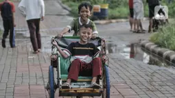 Anak-anak bermain becak mini di sekitar Waduk Kampung Rambutan 2, Jakarta, Kamis (12/11/2020). Waduk seluas 4,6 hektare yang rampung dibangun oleh Pemprov DKI pada 2019 tersebut kini menjadi lokasi wisata alternatif bagi warga setempat, terlebih saat pandemi Covid-19.  (merdeka.com/Iqbal S. Nugroho)