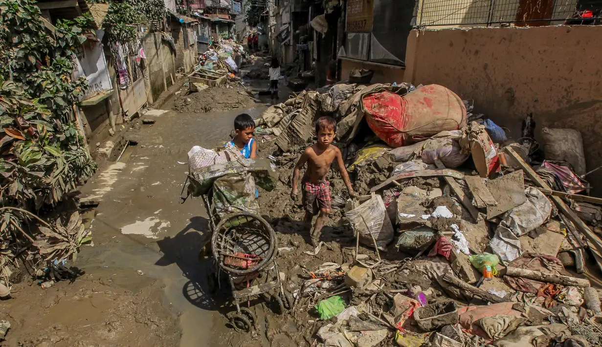 Anak-anak mengumpulkan barang-barang mereka dari endapan lumpur dan sampah beberapa hari setelah bencana banjir yang dipicu oleh Topan Vamco di Marikina City, Filipina, pada 19 November 2020. Dunia merayakan Hari Anak Sedunia tahun ini pada Jumat (20/11). (Xinhua/Rouelle Umali)