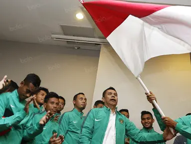 Kapten timnas Indonesia U-19, Andy Setyo Nugroho, mengibarkan bendera merah putih saat upacara pelepasan menuju Piala AFF U-19 2016 di Hotel Ibis Style, Tanggerang, Banten, Jumat (9/9/2016). (Bola.com/Vitalis Yogi Trisna)