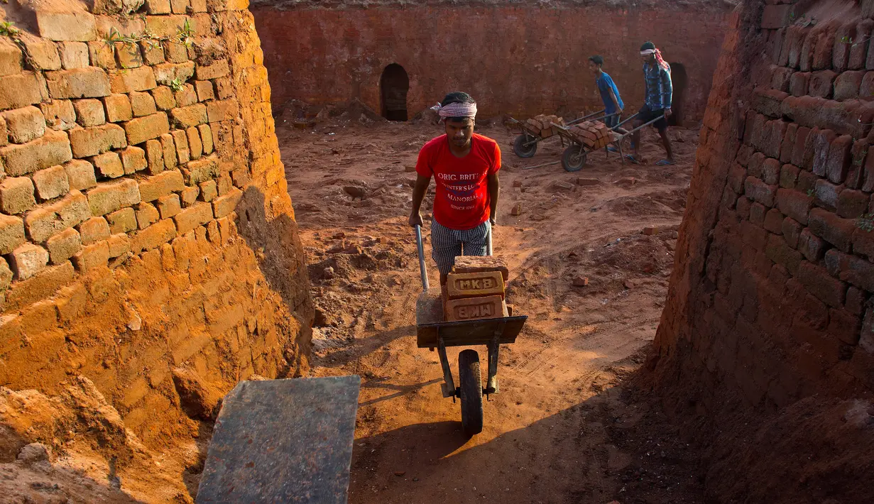 Pekerja India mengangkut batu bata dengan troli di tempat pembakaran batu bata di pinggiran Gauhati, India (22/11). Sebagian besar buruh di sini mendapatkan Rupee 120 (kurang dari 2 Dolar) per hari. (AP Photo/Anupam Nath)