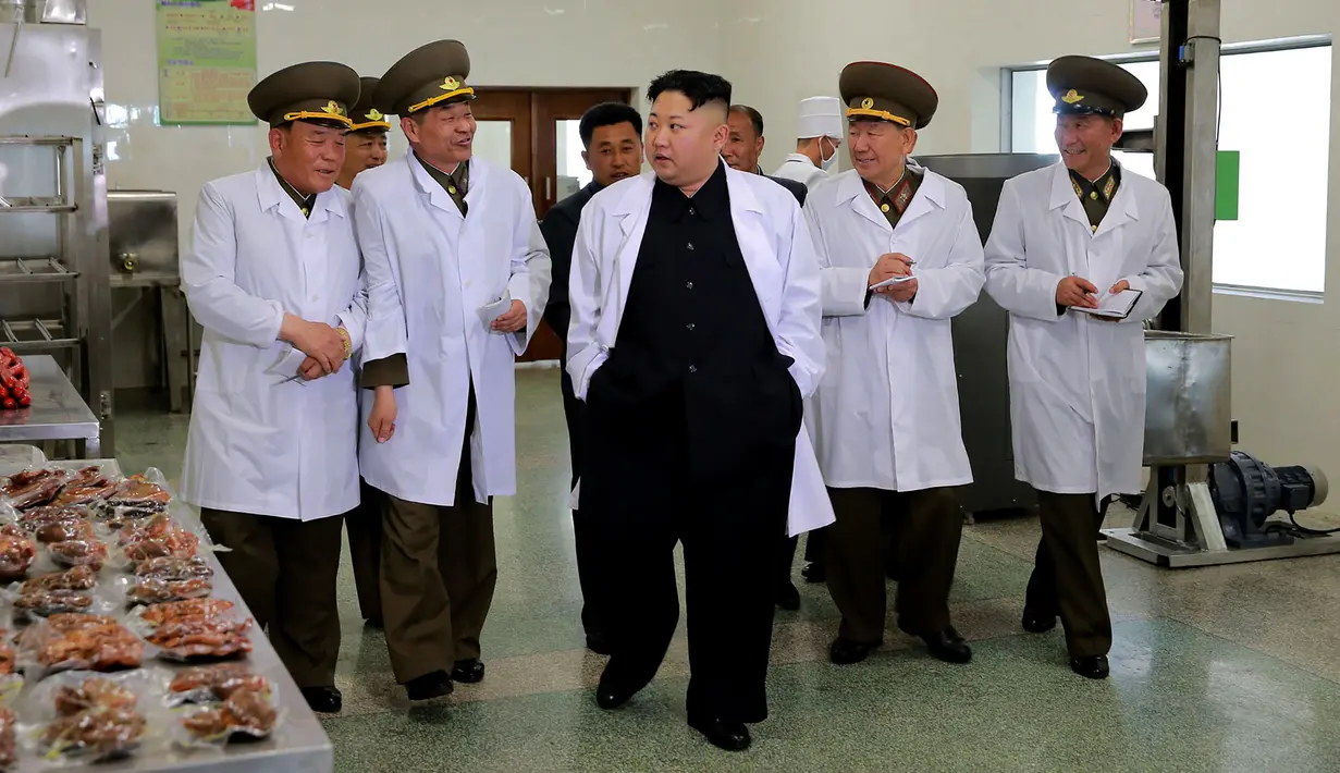 Pemimpin Korea Utara Kim Jong Un berbincang dengan para pejabat saat mengunjungi Peternakan Babi Thaechon di Korea Utara, 23 April 2017. (AFP /Foto/KCNA VIA KNS/Str)