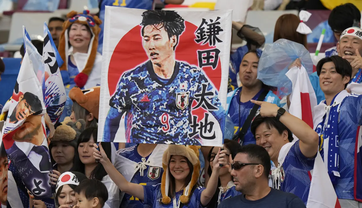 Seorang Suporter wanita membentangkan poster salah satu pemain Jepang sebelum pertandingan grup E Piala Dunia 2022 Qatar antara Jerman dan Jepang di Stadion Internasional Khalifa di Doha, Qatar, Rabu, 23 November 2022. (AP Photo/Luca Bruno)