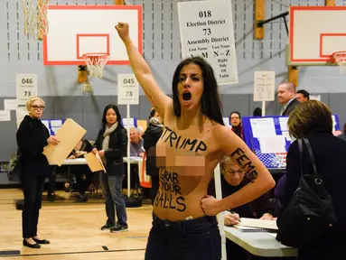 Seorang wanita bertelanjang dada melakukan demonstrasi di TPS Pilpres AS 59, di mana Donald Trump memberikan suaranya di New York, Selasa (8/11). Wanita setengah bugil itu diduga berasal dari kelompok aktivis feminis garis keras. (REUTERS/Darren Ornitz)