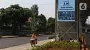 Pedagang melintasi videotron penghormatan kepada tenaga medis yang gugur akibat Covid-19 di tiang penyangga lintasan MRT, Jalan Sisingamangaraja, Jakarta, Jumat (18/9/2020). Keberadaan videotron tersebut diharap mampu membuat masyarakat waspada akan ancaman Covid-19. (Liputan6.com/Herman Zakharia)