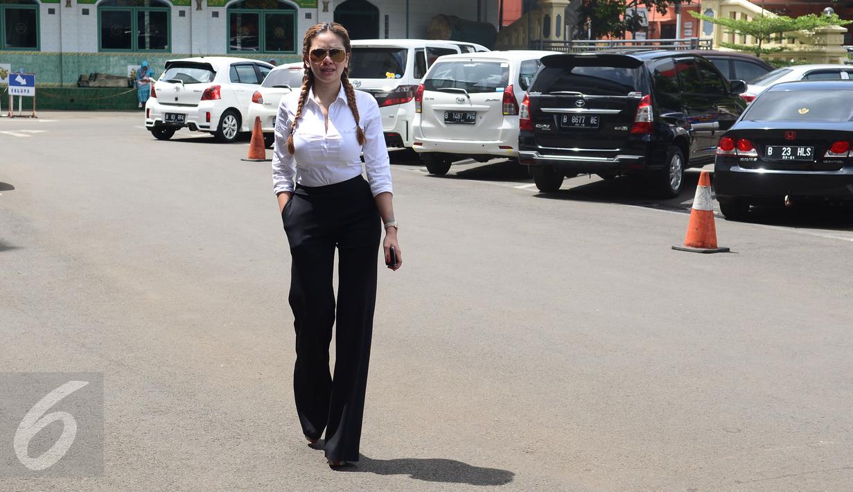 Nikita Mirzani saat tiba di Mapolres Metro Jakarta Selatan, Jumat (23/12). Tampil dengan rambut di kepang dengan busana hitam putih Nikita tampil seksi saat menjadi saksi terkait kasus pemukulan asisten Julia Perez. (Liputan6.com/Herman Zakharia)