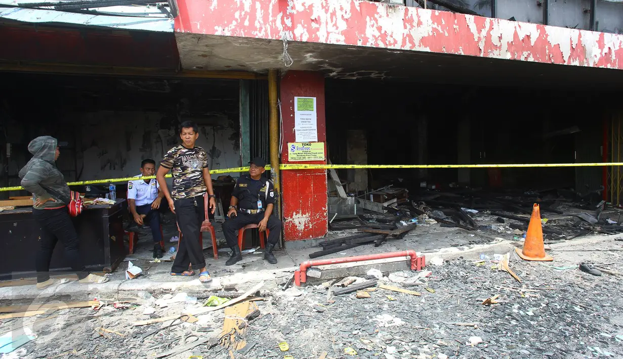 Petugas berjaga di kawasan Pasar Senen, Jakarta, Senin (23/1). Pascakebakaran beberapa hari lalu, para pedagang terpaksa berjualan di luar gedung, meskipun menutup jalan dan mengganggu arus lalu lintas. (Liputan6.com/Immanuel Antonius)