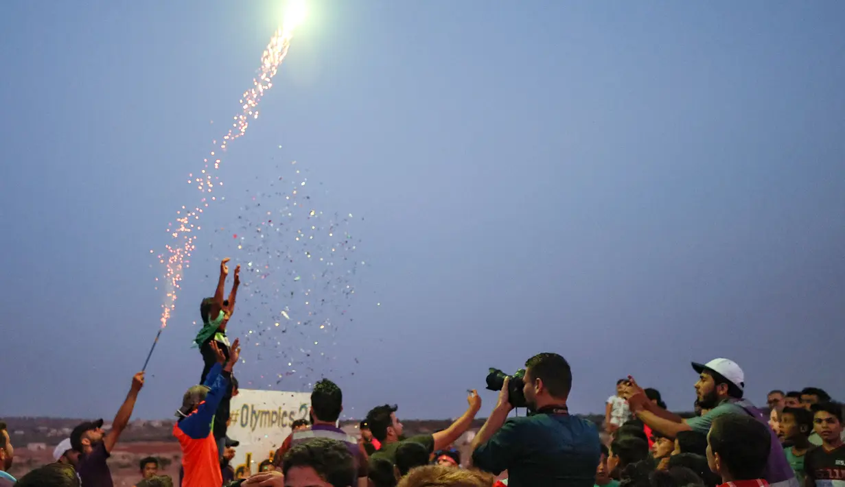 Dan Jelang senja, penyelenggara menembakan hiasan kertas dan menyalakan kembang api sebagai penutup dari pagelaran Olimpiade Tenda 2020 bagi pengungsi di Suriah. (Foto:AFP/Omar Haj Kadour)