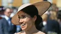 Duchess of Sussex, Meghan Markle menghadiri pesta kebun Istana Buckingham di London, Selasa (22/5). Royal hat senada dari Philip Treacy juga tak kalah menjadikan Meghan Markle tampil mengagumkan. (Dominic Lipinski/Pool Photo via AP)