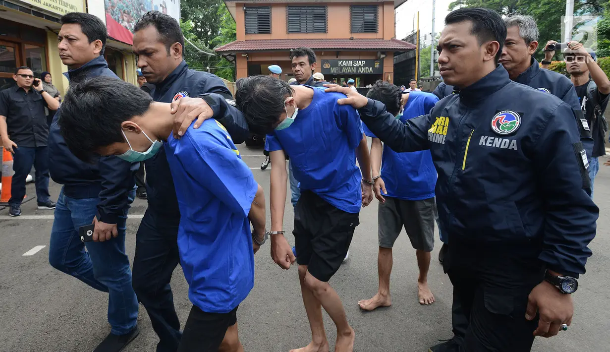 Tiga tersangka perkara kasus pengedaran narkoba jenis shabu dan psikotopika golongan IV serta obat daftar G pada sebuah sekolah berinisial AN, DL, CP dibawa petugas di Polres Jakarta Barat, Selasa (15/1). (Merdeka.com/Imam Buhori)