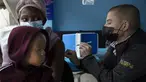 Seorang wanita, dengan anak di pangkuannya, divaksin COVID-19 di sebuah lokasi dekat Johannesburg, Rabu (8/12/2021). Kasus Omicron telah dikonfirmasi setidaknya di sembilan negara Afrika, dengan Afrika Selatan tetap menjadi episenter awal ditemukannya varian baru tersebut. (AP Photo/Denis Farrell)