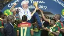 Pemain Kamerun mengangkat sang pelatih, Hugo Broos saat melakukan selebrasi usai menjuarai Piala Afrika 2017 di Stade de I'Amitie, Gabon, Minggu (5/2). Kamerun juara Piala Afrika 2017 setelah menaklukkan Mesir dengan skor akhir 2-1. (ISSOUF SANOGO/AFP)