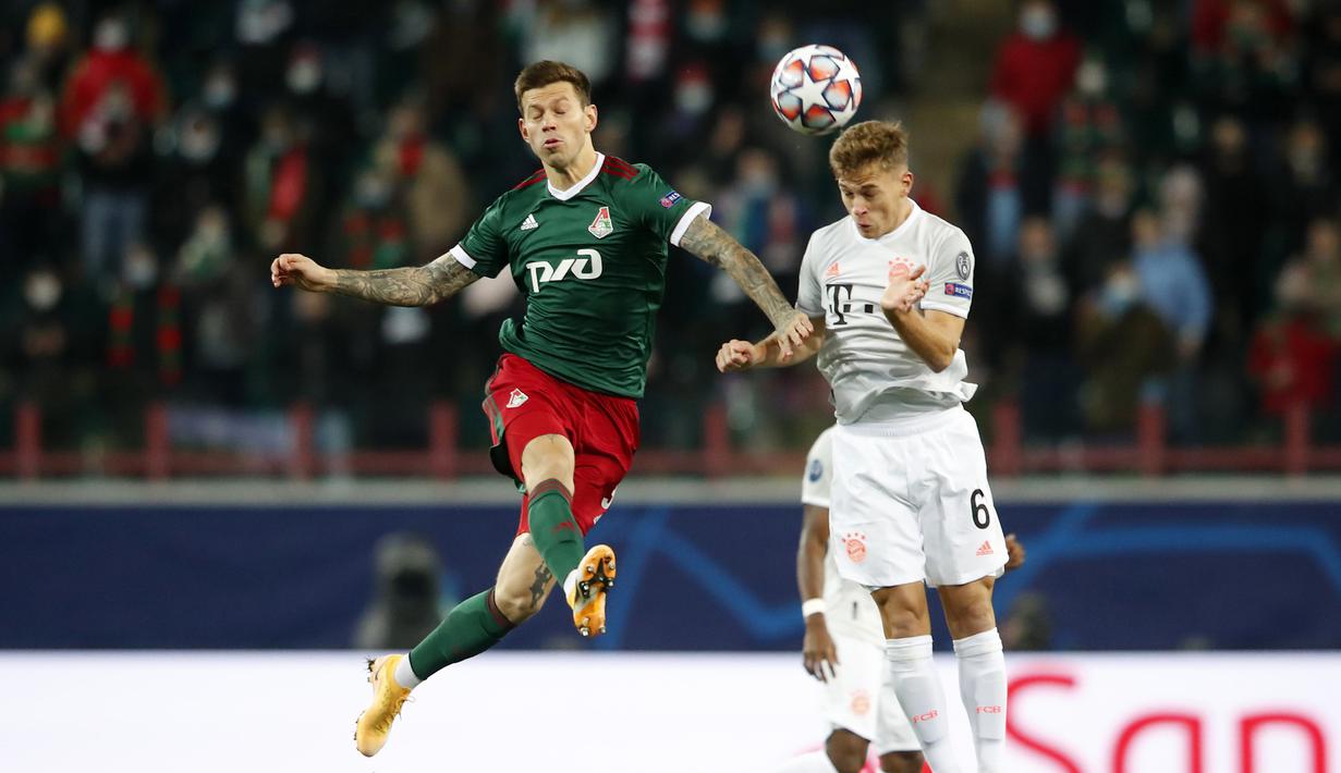 Gelandang Bayern Munchen, Joshua Kimmich, berebut bola dengan gelandang Lokomotiv Moscow, Fedor Smolov, pada laga lanjutan Liga Champions 2020/2021 di RZD Arena, Rabu (28/10/2020) dini hari WIB. Bayern Munchen menang 2-1 atas Lokomotiv. (AFP/Maxim Shemetov/pool)