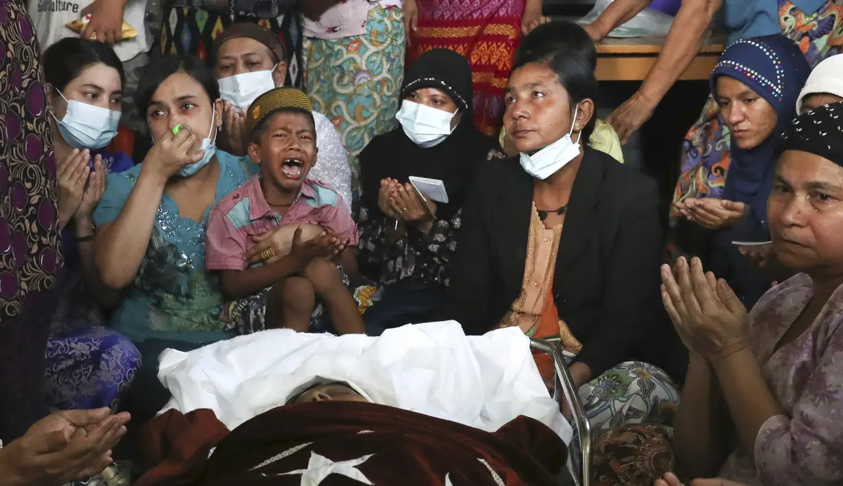 Anggota keluarga dan kerabat berdoa di samping jenazah wanita Muslim yang menurut keluarganya dibunuh oleh tentara hari Minggu saat ikut demonstras menentang kudeta militer Myanmar, saat upacara pemakamannya di Mandalay, Myanmar, Senin (1/3/2021). (AP Photo)