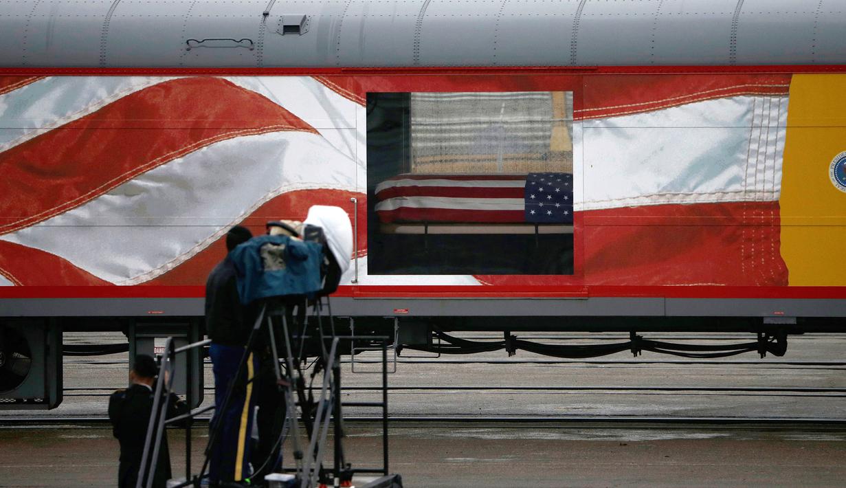 Peti jenazah Presiden ke-41 AS George HW Bush ditempatkan dalam sebuah kereta di Union Pacific Westfield, Spring, Texas, Kamis (6/12). Kereta pembawa jenazah George HW Bush menempuh perjalanan sejauh 112 kilometer. (AP Photo/Kiichiro Sato)