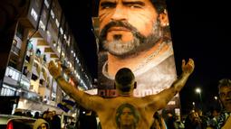 Fans merayakan ulang tahun Diego Maradona di bawah mural legenda sepak bola itu di Distrik San Giovanni, Napoli, Italia, 30 Oktober 2022. Legenda sepak bola asal Argentina, Diego Armando Maradona yang lahir pada 30 Oktober 1960 meninggal pada 25 November 2020. (Alessandro Garofalo/LaPresse via AP)