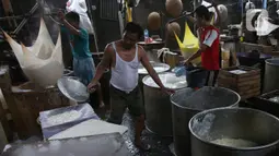 Pekerja menyelesaikan pembuatan tahu di industri rumahan kawasan Jakarta, Selasa (17/12/2019). Pemerintah juga menaikkan plafon penyaluran KUR plafon secara signifikan 36% dari Rp 140 triliun menjadi Rp 190 triliun tahun 2020. (Liputan6.com/Angga Yuniar)