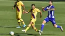 Pemain Barcelona, Jordi Alba, berebut bola dengan pemain Alaves, Luis Rioja, pada laga La Liga di Stadion Mendizorroza, Minggu (19/7/2020). Barcelona menang dengan skor 5-0. (AP/Alvaro Barrientos)
