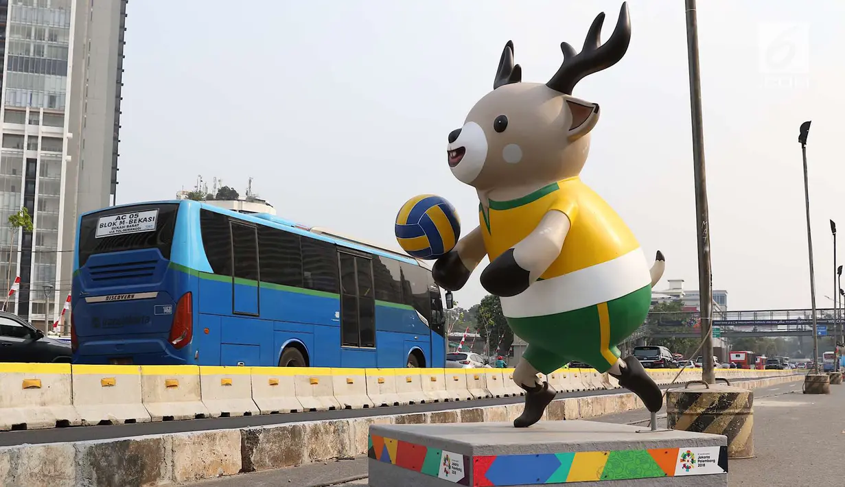 Bus Transjakarta melintas di samping patung maskot Asian Games 2018 yang menghiasi Jalan Sudirman, Jakarta, Rabu (8/8). Pemasangan maskot tersebut untuk menyemarakan Asian Games 2018 yang akan dibuka 18 Agustus 2018. (Liputan6.com/Immanuel Antonius)