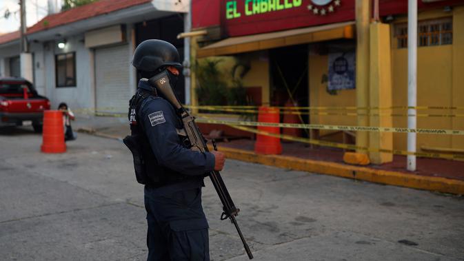 Polisi menjaga klub penari telanjang yang menjadi lokasi penyerangan di Coatzacoalcos, Veracruz, Meksiko, Rabu (28/8/2019). Beberapa media Meksiko melaporkan, orang-orang bersenjata telah melepaskan tembakan ke bar sebelum akhirnya melemparkan bom molotov. (AP Photo/Felix Marquez)