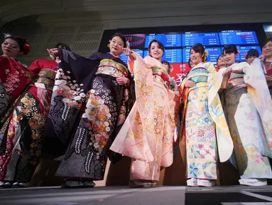 Sejumlah wanita mengenakan busana kimono berpose setelah pembukaan pasar saham untuk tahun ini di Bursa Saham Tokyo, Jepang (4/1). Mereka hadir sebagai bagian dari upacara pembukaan bursa saham yang digelar setiap awal tahun. (AP Photo/Eugene Hoshiko)