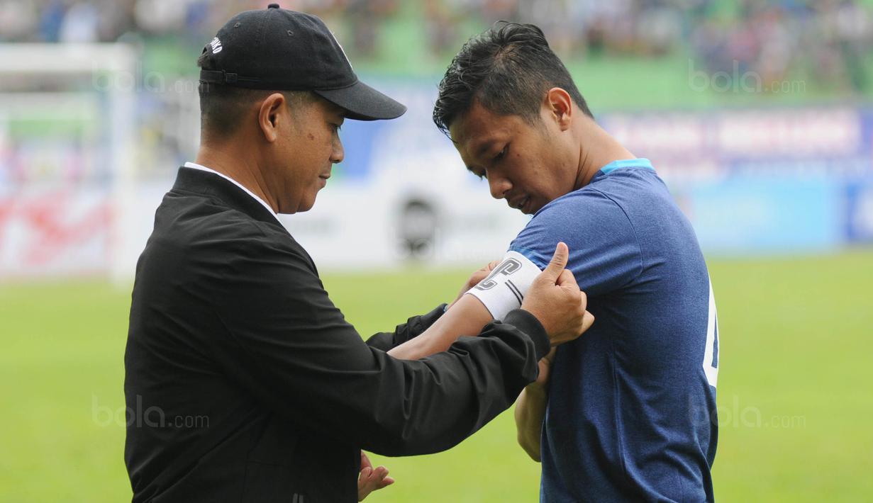 Pelatih Arema FC, Joko Susilo, menyematkan ban kapten kepada Dendi Santoso sebelum laga uji coba melawan PSIS di Stadion Gajayana, Malang, Kamis (4/1/2018). Arema FC menang 5-3 atas PSIS. (Bola.com/Iwan Setiawan)
