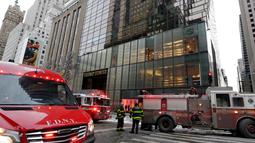Kendaraan petugas pemadam berada di lokasi kebakaran di Fifth Avenue, depan Trump Tower, di New York, Senin (8/1). Sebanyak 84 petugas pemadam kebakaran dikerahkan untuk memadamkan api di puncak gedung berlantai 68 itu. (AP Photo/Richard Drew)