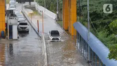 Sejumlah kendaraan melintasi Gerbang Tol Karang Tengah Barat 2 yang masih terendam banjir, Tangerang, Banten, Kamis (2/1/2020). Banjir setinggi betis orang dewasa masih menggenangi Gerbang Tol Karang Tengah Barat 2. (Liputan6.com/Angga Yuniar)