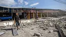 Seorang pria berjalan di tengah puing-puing bangunan yang rusak akibat gempa berkekuatan magnitudo 7,7 di Borong, Manggarai Timur, Nusa Tenggara Timur, Minggu, 16 Agustus 2026.. (AFP/ Juni Kriswanto)