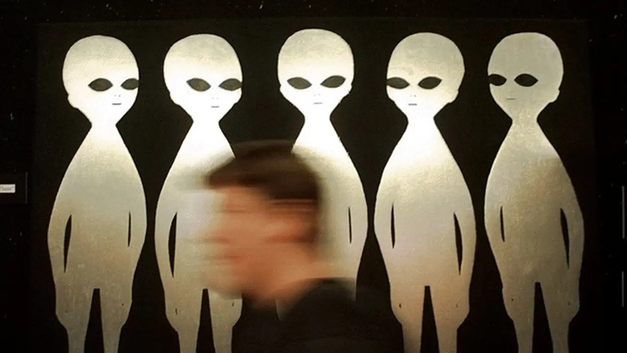 Seorang pengunjung berjalan melewati sebuah lukisan di International UFO Museum and Research Center di Roswell, New Mexico, AS, pada 10 Juni 1997.