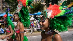 Sejumlah penari wanita mengenakan hiasan kepala saat mengikuti parade West Indian Day di Brooklyn, New York, Senin (3/9). Komunitas Karibia di New York telah mengadakan perayaan tahunan Karnaval sejak tahun 1920. (AP Photo/Craig Ruttle)