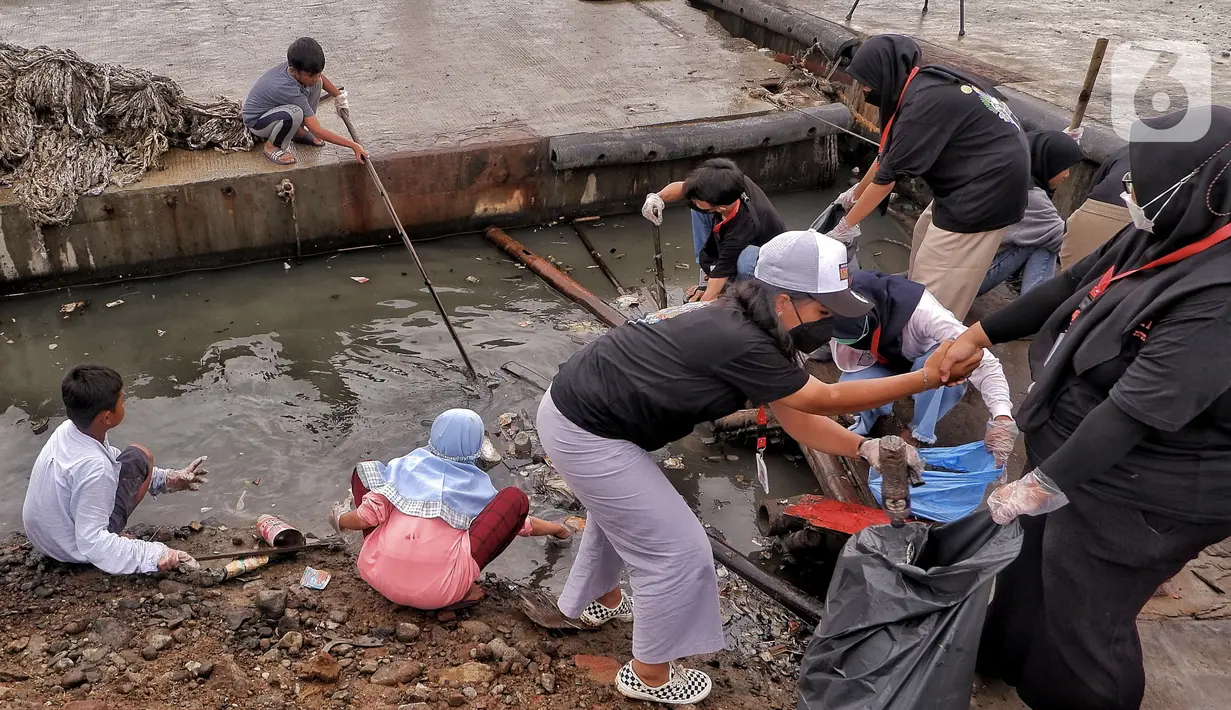 Anak-anak pesisir membersihkan sampah di kawasan Cilincing, Jakarta Utara, Minggu (5/12/2021). Fenomena rob yang diprediksi BMKG berlangsung dari 2-9 Desember 2021 di Jakarta menginisiasi anak-anak Kelas Jurnalis Cilik untuk bersih-bersih kawasan pesisir. (merdeka.com/Iqbal S. Nugroho)