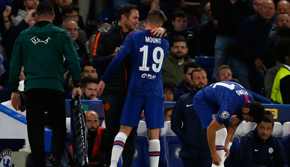 Manajer Chelsea, Frank Lampard berbincang dengan Mason Mount setelah mengalami cedera pada laga perdana Grup H Liga Champions melawan  Valencia di Stamford Bridge, Rabu (18/9/2019). Debut Lampard bersama Chelsea di Liga Champions tercoreng dengan kekalahan 0-1 atas Valencia. (Ian KINGTON / AFP)