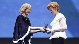 Aktris Tilda Swinton (kanan) menerima trofi Golden Lion for Lifetime Achievement dari Presiden Juri Cate Blanchett pada upacara pembukaan Venice Film Festival ke-77 di Venesia, Italia, Rabu (2/9/2020). Venice Film Festival tahun ini berlangsung dari 2-12 September. (AP Photo/Domenico Stinellis)