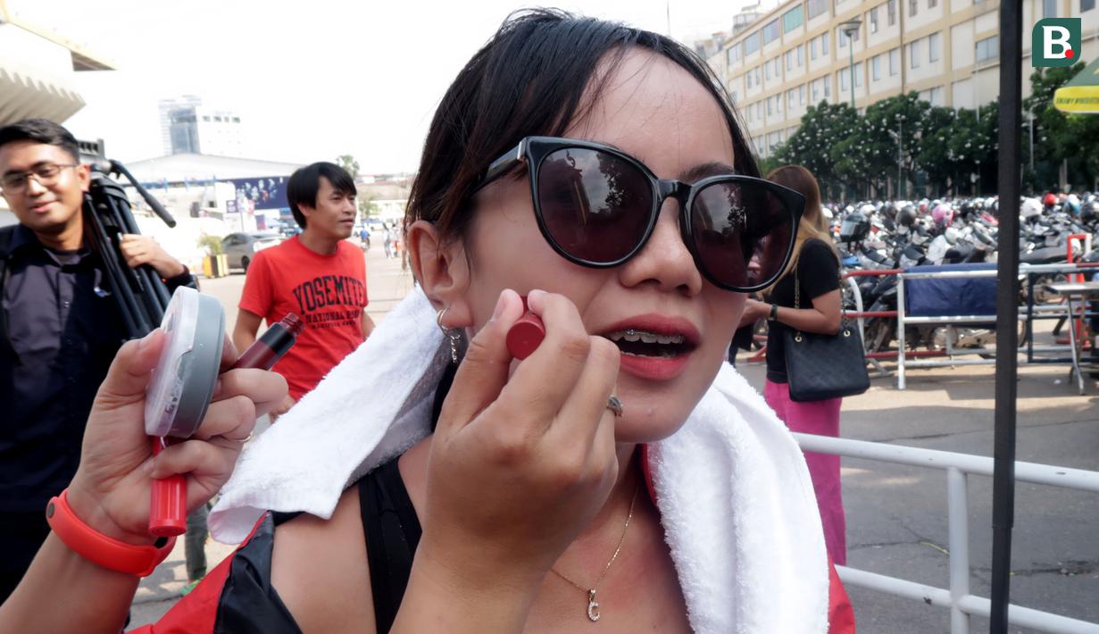 Seorang pendukung Indonesia mewarnai pipinya saat menunggu laga kedua Grup A Sepak Bola SEA Games 2023 antara Timnas Indonesia melawan Timnas Myanmar di Olympic Stadium, Phnom Penh, Kamboja, Kamis (04/05/2023). Skuad asuhan Indra Sjafri tersebut berhasil menang dengan skor telak 5-0. (Bola.com/Gregah Nurikhsani)