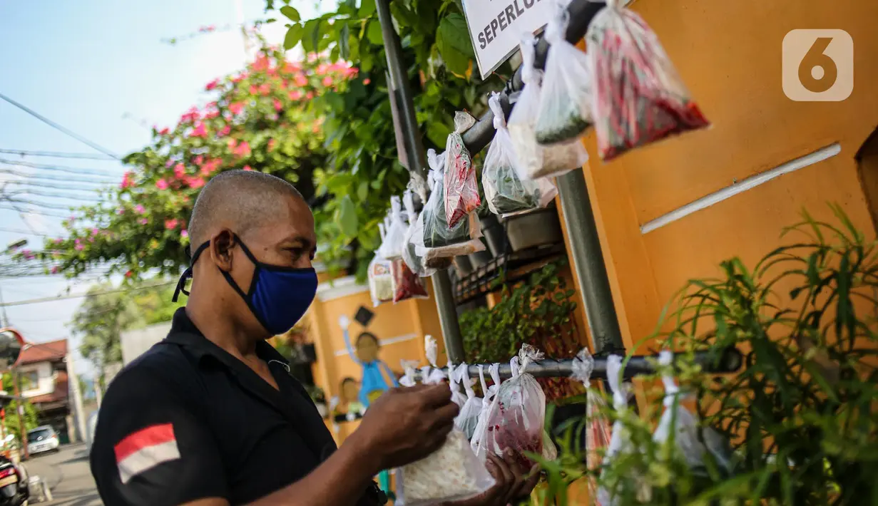 Warga memilih sayur mayur hasil sumbangan di RT 02 RW 04, Kelurahan Jati Padang, Jakarta, Jumat (22/5/2020). Pakaian bekas layak pakai serta sayur mayur disediakan bagi warga terdampak Pembatasan Sosial Berskala Besar (PSBB) untuk pencegahan COVID-19. (Liputan6.com/Faizal Fanani)