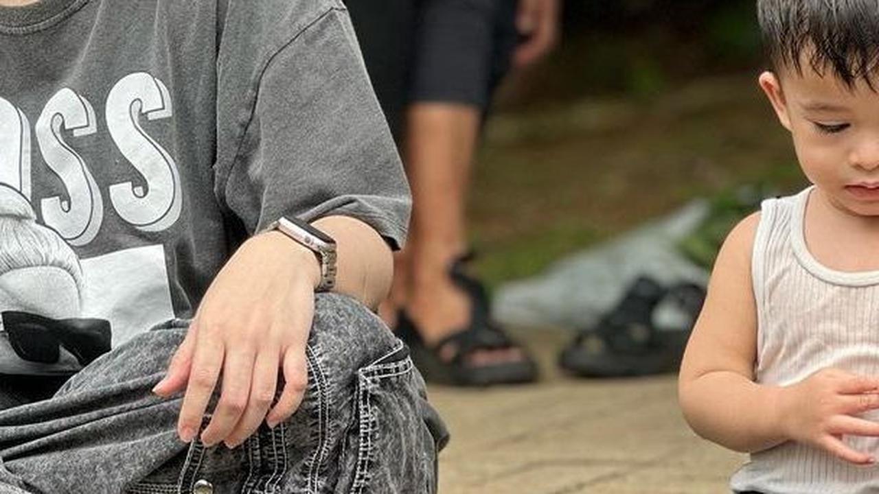 Tak sendiri, Nathalie terlihat bersama dengan sang anak, Adzam Adriansyah Sutisna yang tampak sedang bermain air di kolam ikan.