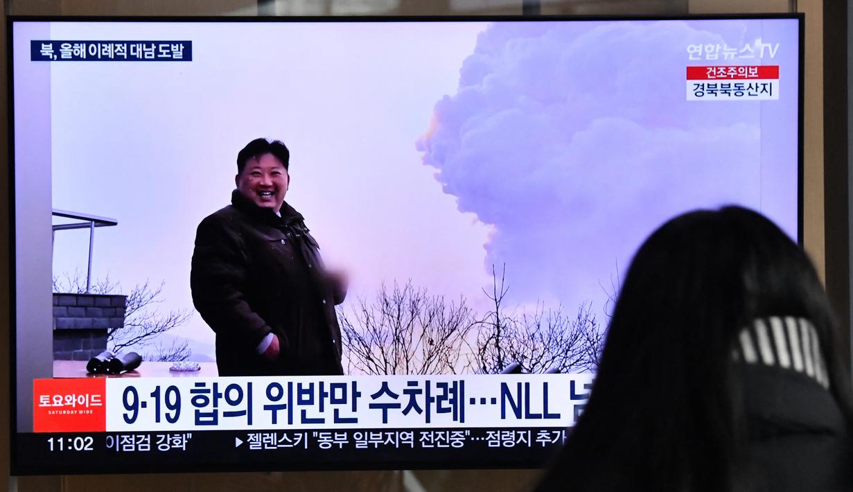 Seorang perempuan menonton layar televisi yang menayangkan siaran berita dengan rekaman file pemimpin Korea Utara Kim Jong Un, di sebuah stasiun kereta api di Seoul, Sabtu (31/12/20220). Tidak termasuk peluncuran rudal pada hari ini, Kantor berita Yonhap melaporkan, Korea Utara telah menembakkan sekitar 70 rudal balistik tahun ini, termasuk sekitar delapan rudal balistik antarbenua (ICBM). (Jung Yeon-je / AFP)