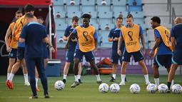 Penyerang Inggris #17 Bukayo Saka (Tengah) dan rekan satu timnya ambil bagian dalam sesi latihan jelang kontra Prancis pada perempat final Piala Dunia 2022, di Stadion Al Wakrah SC, selatan Doha, Jumat (9/12/2022). Kemenangan menjadi harga mutlak untuk didapatkan kedua tim demi mendapatkan tempat di babak semifinal. (Paul ELLIS / AFP)