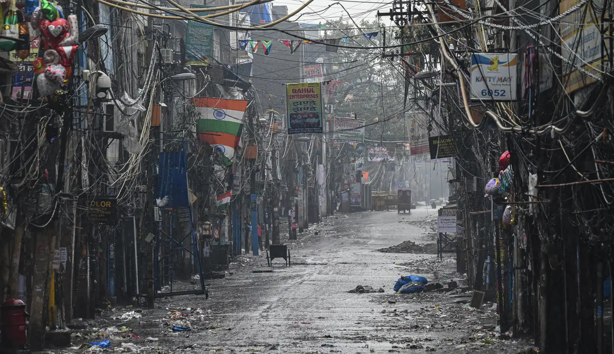 Sebuah jalan sepi terlihat di Sadar Bazar selama jam malam akhir pekan di New Delhi, India, Sabtu (8/1/2022). Pihak berwenang memberlakukan jam malam selama akhir pekan di seluruh negara bagian Delhi saat jumlah kasus covid-19 kembali melonjak. (Prakash SINGH/AFP)