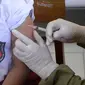 Petugas Puskesmas memberikan imunisasi campak kepada siswa kelas I saat pelaksanaan Bulan Imunisasi Anak Sekolah (BIAS) di SDN Serua 3, Ciputat, Tangsel, Selasa (1/9/2020). Kegiatan itu untuk memberikan kekebalan terhadap siswa dari penyakit campak, difteri dan tetanus. (merdeka.com/Dwi Narwoko)