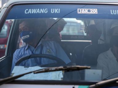 Sopir angkutan umum Jak Lingko mengenakan masker dan sarung tangan di kawasan Cawang, Jakarta, Senin (6/7/2020). Pada perpanjangan masa PSBB transisi, angkutan umum sudah mulai beroperasi kembali dengan menerapkan protokol Kesehatan Covid-19. (Liputan6.com/Faizal Fanani)