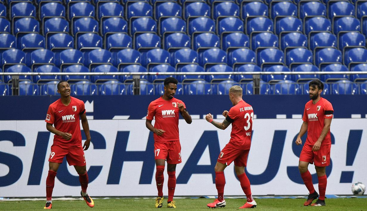 Pemain Augsburg, Noah Saranren Bazee, melakukan selebrasi usai membobol gawang Schalke 04 pada laga Bundesliga di Veltins-Arena, Minggu (24/5/2020). Augsburg menang dengan skor 3-0 atas Schalke 04. (AP/Martin Meissner)