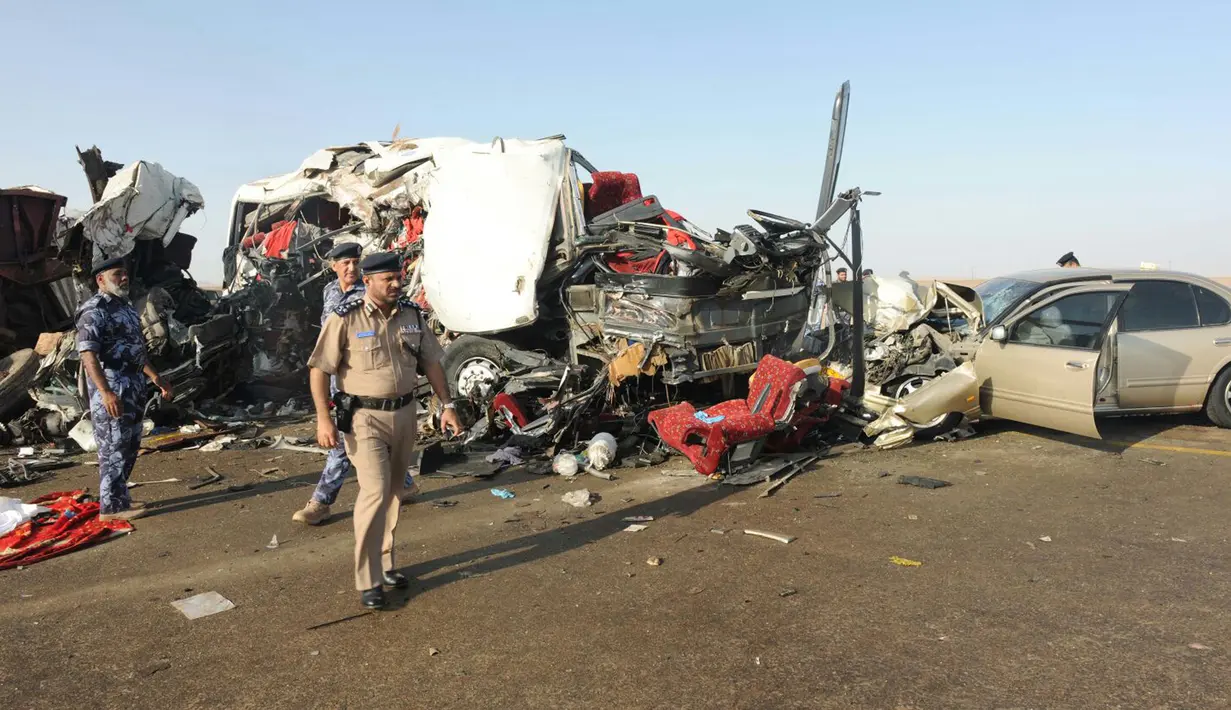 Sebuah gambar memperlihatkan bangkai bus dan truk yang mengalami kecelakaan di jalan raya antara Ibri dan Fahud, Oman bagian barat, Selasa (1/3). Sebanyak 18 orang dari beberapa kewarganegaraan tewas dan 14 lainnya luka-luka. (STRINGER/Omani Police/AFP)